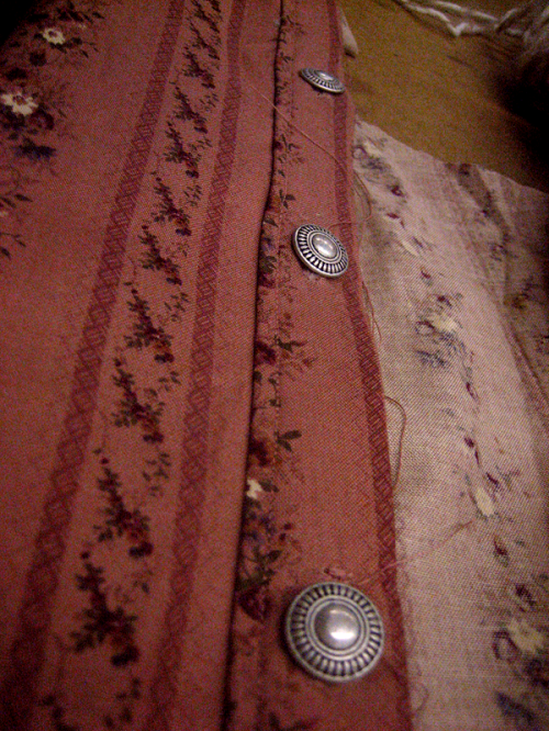 Rose-pink floral fabric button band with ornate silver buttons